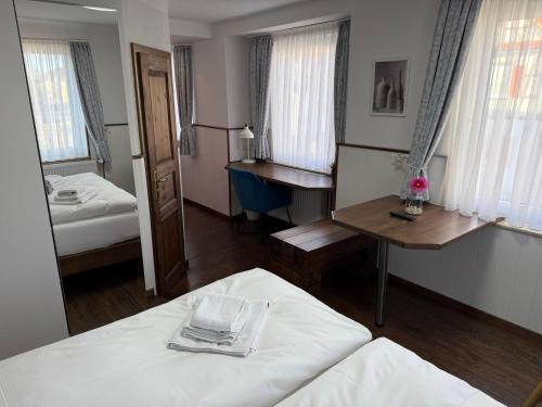 a room with two beds and a table and a mirror at Hotel Schöne Aussicht in Bad Friedrichshall