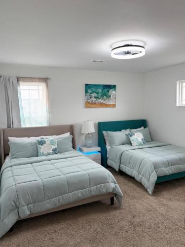 two beds in a room with white walls at The Cozy Haven in Owasso