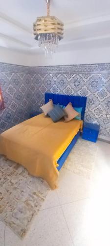 a blue bed in a room with a chandelier at Résidence chez Said in Sidi Ifni