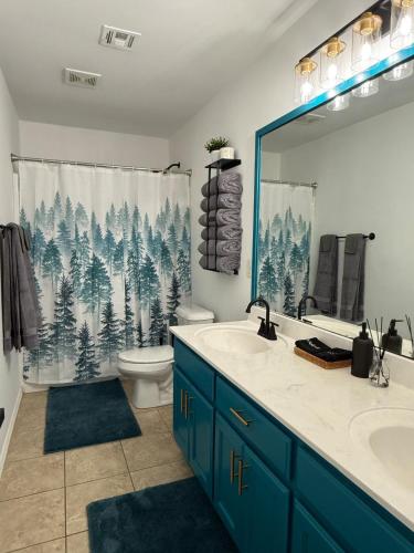 a bathroom with a sink and a toilet and a shower curtain at The Cozy Haven in Owasso