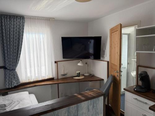 a bedroom with a bed and a flat screen tv at Hotel Schöne Aussicht in Bad Friedrichshall