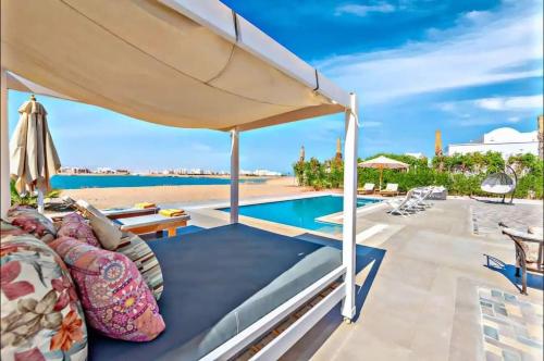 a patio with an umbrella and a swimming pool at Luxury villa in gouna in El Gouna