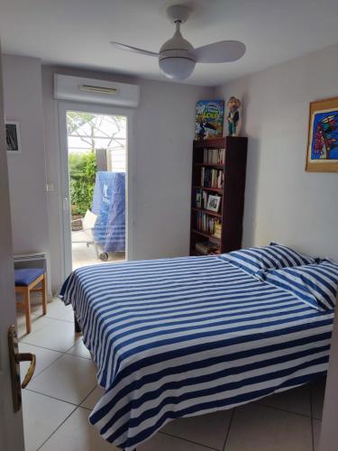 - une chambre avec un lit rayé bleu et blanc dans l'établissement Garden level near Nice, à Saint-Laurent-du-Var