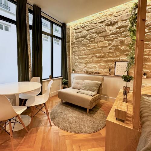 - un salon avec un mur en pierre et une table dans l'établissement Studio Amelot, Charming & Pierre, à Paris