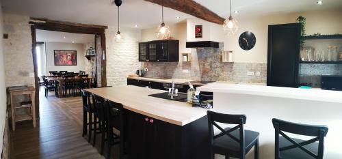 une cuisine avec un comptoir et un îlot de cuisine avec des chaises dans l'établissement 4 place de la Rose, à Castelnau-de-Montmiral