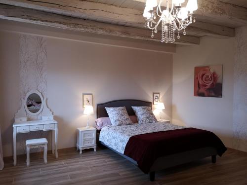 une chambre avec un lit et un lustre dans l'établissement 4 place de la Rose, à Castelnau-de-Montmiral