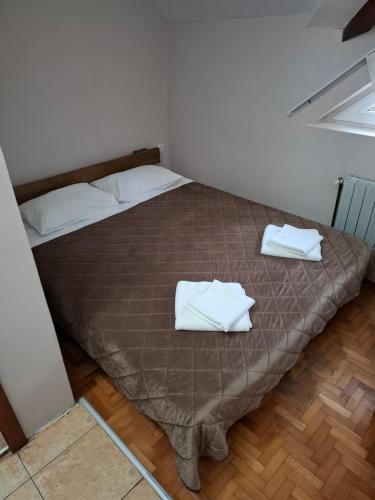 a bedroom with a bed with two white towels on it at Hotel Koliba na Grza in Kilsura