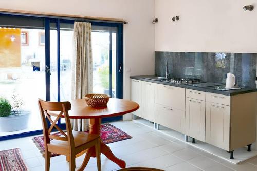 une cuisine avec une table en bois et une table et des chaises dans l'établissement Appartement charmant à Saint-Quentin-la-Poterie, 40 m², jardin., à Saint-Quentin-la-Poterie