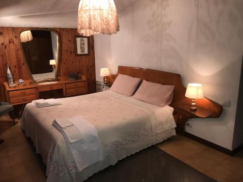 a bedroom with a bed and a mirror and lamps at Casa Gramapa in Rocca Priora