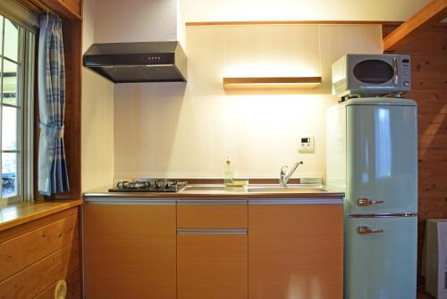 a kitchen with a refrigerator and a sink at PICA Fujiyoshida in Fujiyoshida