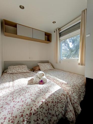a bedroom with two beds and a window at Casa Mobil-Home in La Puebla de los Infantes