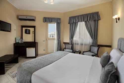 a hotel room with a bed and two chairs at Holidays Express Hotel in Cairo