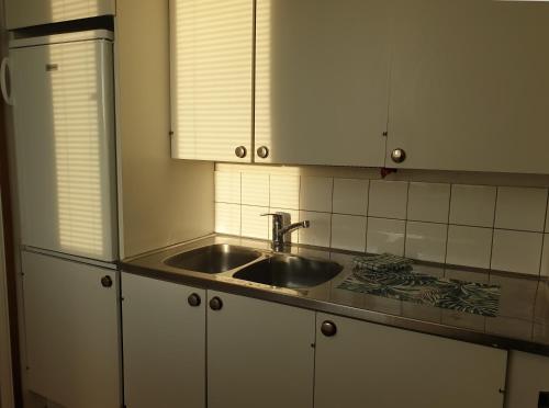 a kitchen with a sink and white cabinets at Metsola in Pielavesi