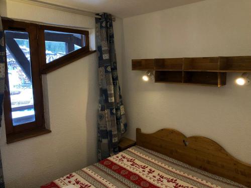 une petite chambre avec un lit et une fenêtre dans l'établissement **Appartement T3 skis aux pieds avec balcon, parking et ski-casier, idéal pour skieurs !** - FR-1-513-18, à La Tania
