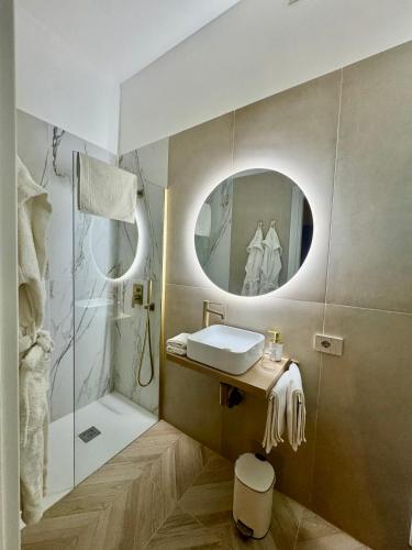 a bathroom with a sink and a shower with a mirror at NapoliOn - Luxury Apartment in Naples
