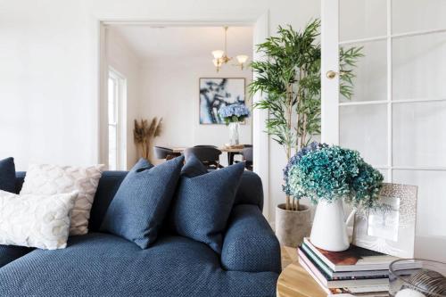 a blue couch in a living room with plants at VAQUAY The Hamptons In Williamstown in Williamstown