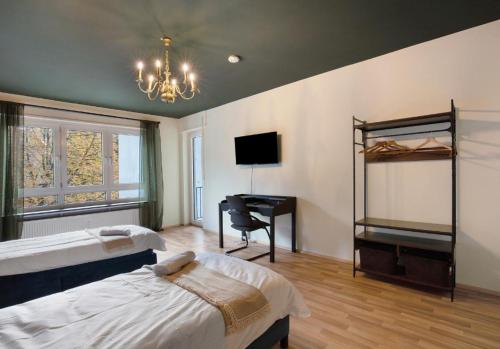 a bedroom with two beds and a desk with a computer at Apartment Salvo in Mannheim