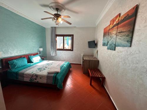 a bedroom with a bed and a ceiling fan at Hotel L'Initiale in Oualidia