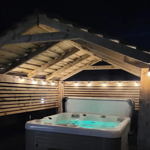 a bath tub in a room with a ceiling with lights at Ballyhemlin Pods - Haw thorn in Bushmills