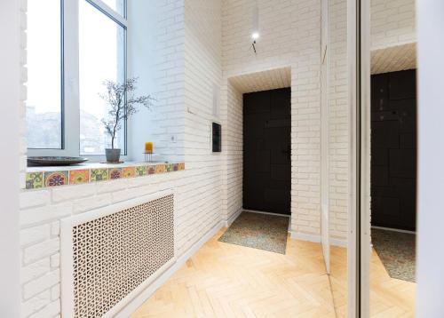 un corridoio con pareti di mattoni bianchi e una porta nera di Kyiv Scandi Apartment a Kiev