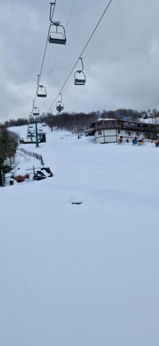 a ski lift over a snow covered ski slope at Perlyna Krasiyi in Vyshka