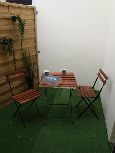 une table, deux chaises, une table et deux tasses dans l'établissement Maison 43m2 meublée 200m plage, à La Bernerie-en-Retz