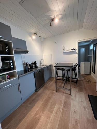 - une cuisine avec une table au milieu d'une pièce dans l'établissement Maison 43m2 meublée 200m plage, à La Bernerie-en-Retz