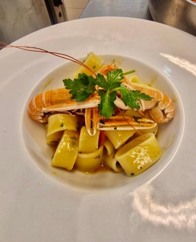 a plate of food with fish and pasta on a table at Hotel Albatros in Ischia
