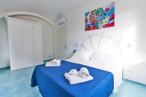 a bedroom with a blue bed with towels on it at Seashell apartment in Minori
