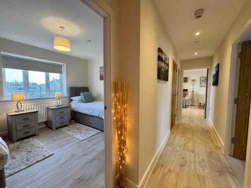 a bedroom with a bed and a hallway with lights at Gwel Y Bae-2 Bed-en-suite-Lift-Pet friendly in Trearddur
