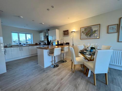 a kitchen and dining room with a table and chairs at Gwel Y Bae-2 Bed-en-suite-Lift-Pet friendly in Trearddur