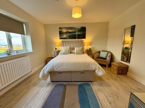 a bedroom with a large bed and a window at Gwel Y Bae-2 Bed-en-suite-Lift-Pet friendly in Trearddur
