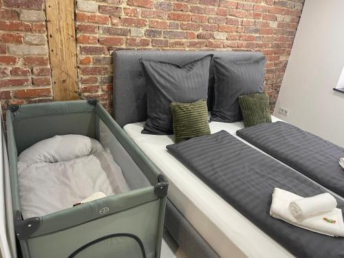 two beds in a room next to a brick wall at ADVENTURE LuxusApartment in Wetzlar