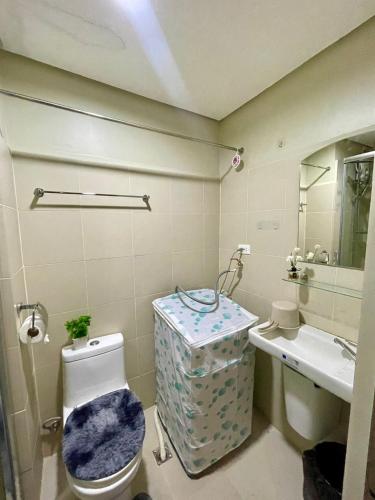 a bathroom with a toilet and a sink at Fame Residence Retreat Cozy 1BR with Balcony in Manila