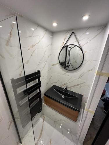 une salle de bain avec un lavabo noir et un miroir dans l'établissement Roméo et Juliette, à Cahors