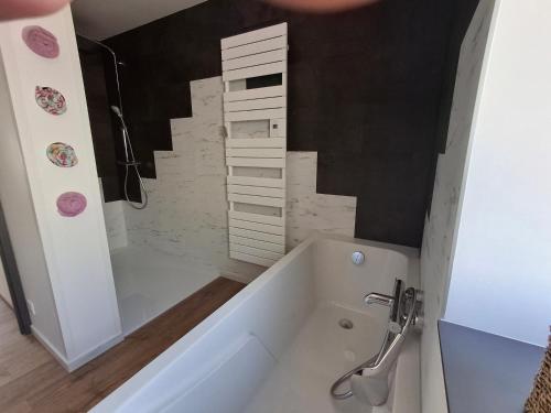 une salle de bain avec une baignoire et un lavabo dans l'établissement Auxpetitsloups, à Issancourt-et-Rumel