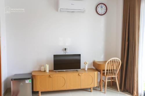 a living room with a television on a wooden cabinet at Moonstone Homestay & Cafe - Vinhomes Ocean Park 2 in Hòa Bình