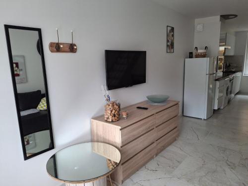 un salon avec une télévision et une table en verre dans l'établissement Auxpetitsloups, à Issancourt-et-Rumel