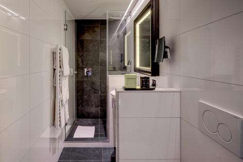 a white bathroom with a sink and a mirror at Romantik Hotel Mont Blanc au Lac in Morges