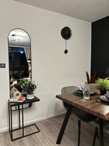 a dining room with a table and a mirror at Spacious and modern flat in Archway in London
