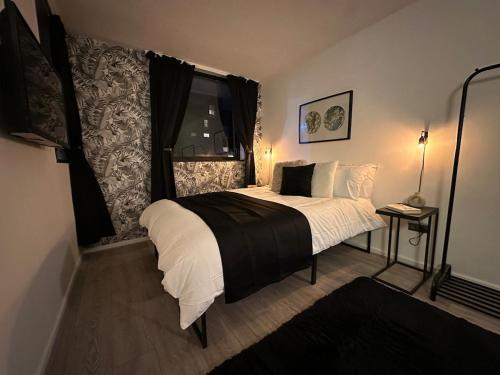a bedroom with a bed with white sheets and a window at Spacious and modern flat in Archway in London