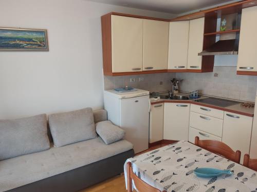 a living room with a couch and a table and a kitchen at Apartma Marea in Izola