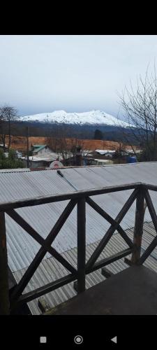 a wooden deck with snow covered mountains in the background at Cabaña Belén in Neltume