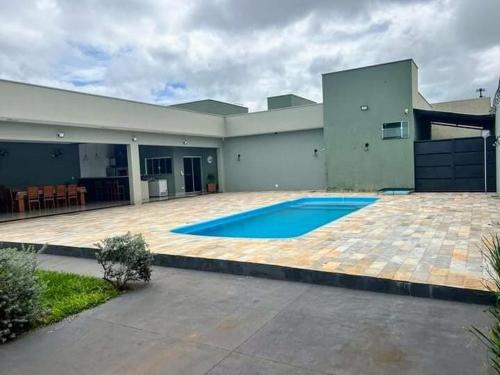 a large house with a swimming pool in the yard at Casa para temporada in Presidente Epitácio