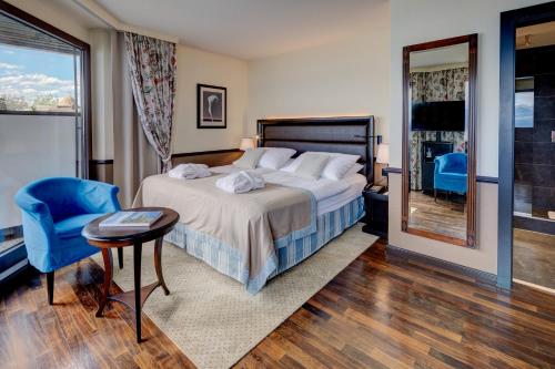 a bedroom with a bed and a table and a chair at Romantik Hotel Mont Blanc au Lac in Morges