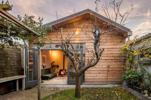 a wooden house with a tree in front of it at Deborah's Hiding Place in Alkmaar