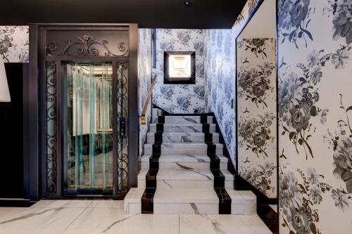 a hallway with a staircase leading to a door with wallpaper at Romantik Hotel Mont Blanc au Lac in Morges
