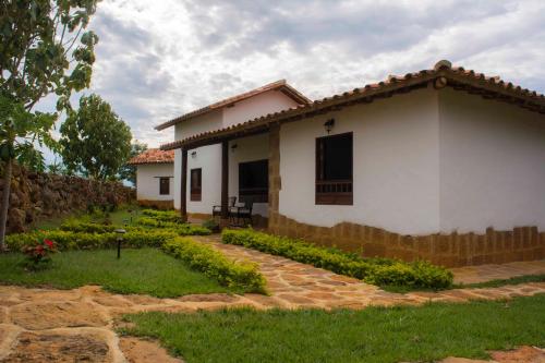 a white house with a stone walkway in front of it at Casa Bari La Antigua in Barichara