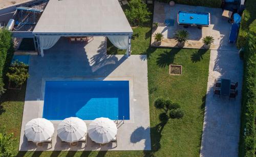 an overhead view of a swimming pool with umbrellas at Villa Shameti - Private Villa with Pool and Billiards Near Zakynthos Town By Villa Mana Gers in Zakynthos Town