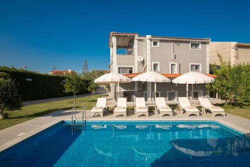 a pool with chairs and umbrellas next to a building at Villa Shameti - Private Villa with Pool and Billiards Near Zakynthos Town By Villa Mana Gers in Zakynthos Town